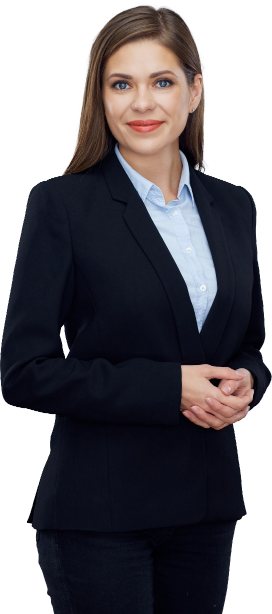 Woman in a professional outfit with a black blazer over a light blue shirt, long brown hair styled straight, and a friendly expression. She stands confidently with her hands clasped, exuding a polished and approachable demeanor